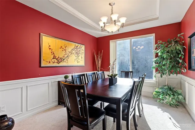 a view of a dining room with furniture a chandelier and wooden floor