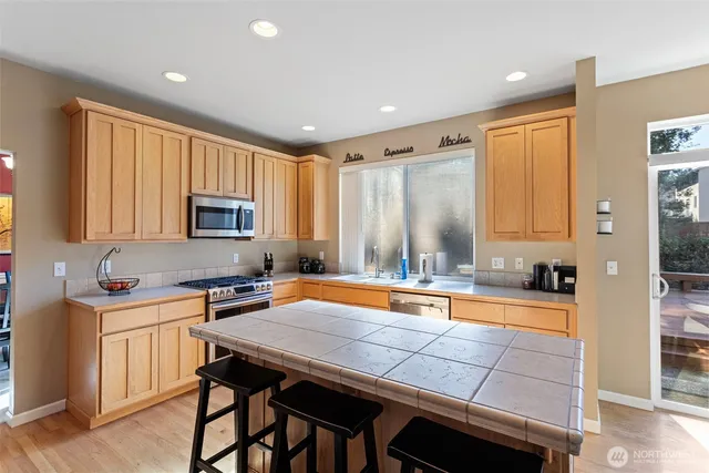 a kitchen with a table chairs sink and cabinets