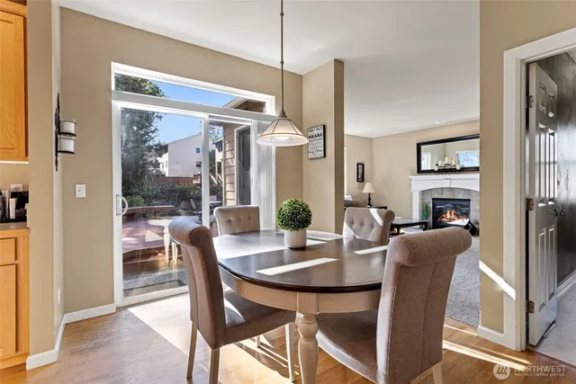 a dining room with furniture a floor to ceiling window and wooden floor