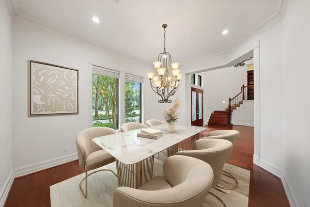 a dining room with furniture a chandelier and wooden floor