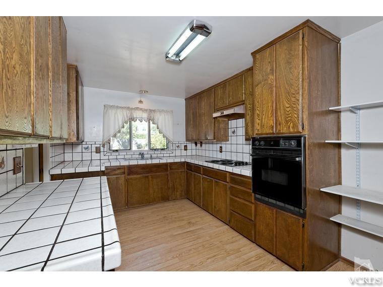 4361 Adam Road Simi Valley, CA 93063 - Photo 6 of 12 a kitchen with stainless steel appliances kitchen island granite countertop a stove a sink and a microwave
