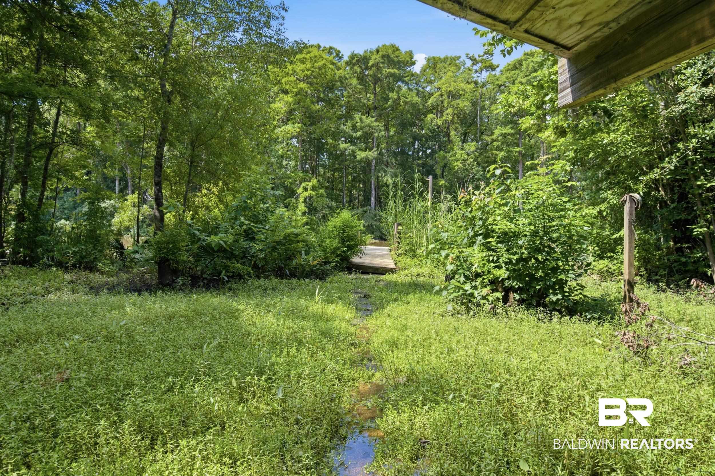 42080 Bayou Road Bay Minette, AL 36507 - Photo 29 of 43 Lush natural landscape with a wooden boardwalk spanning a verdant area