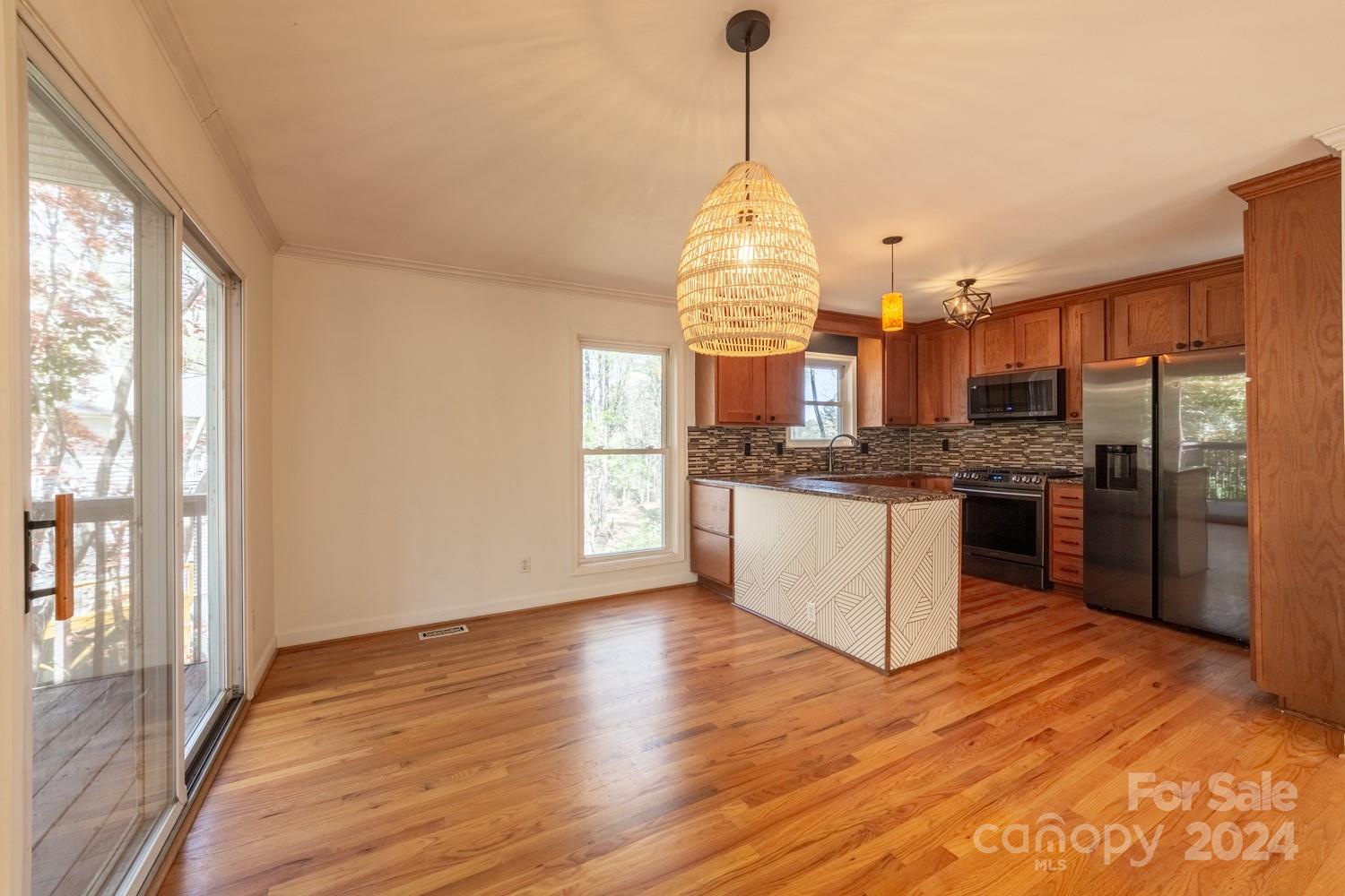 1177 Molokai Drive Tega Cay, SC 29708 - Photo 13 of 41 a view of a kitchen with kitchen island wooden floors stainless steel appliances and a chandelier