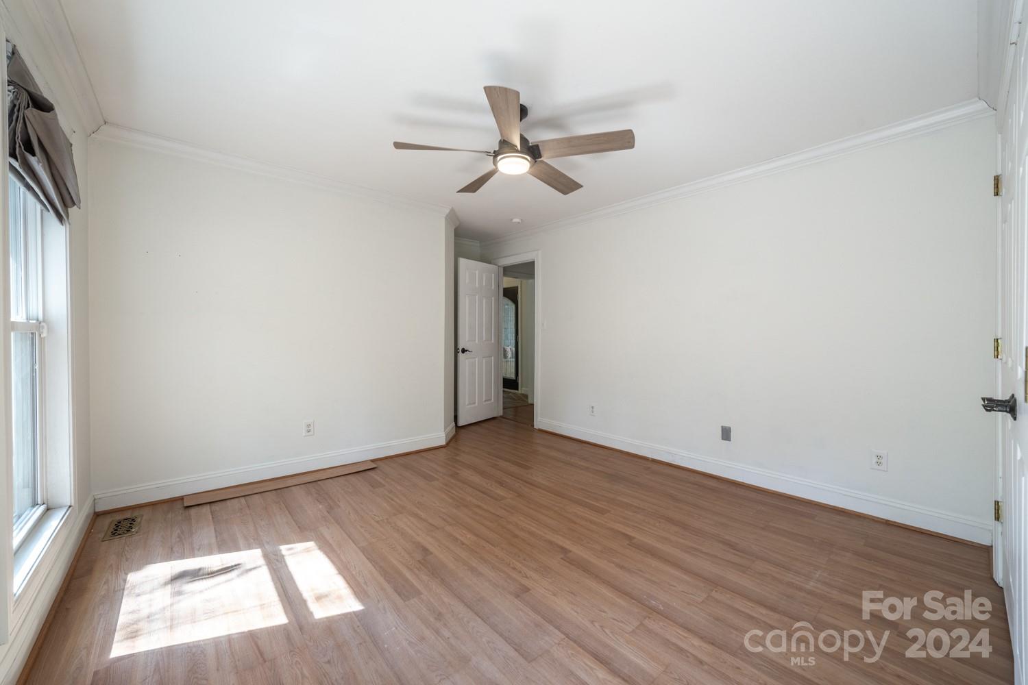 1177 Molokai Drive Tega Cay, SC 29708 - Photo 21 of 41 an empty room with wooden floor ceiling fan and windows