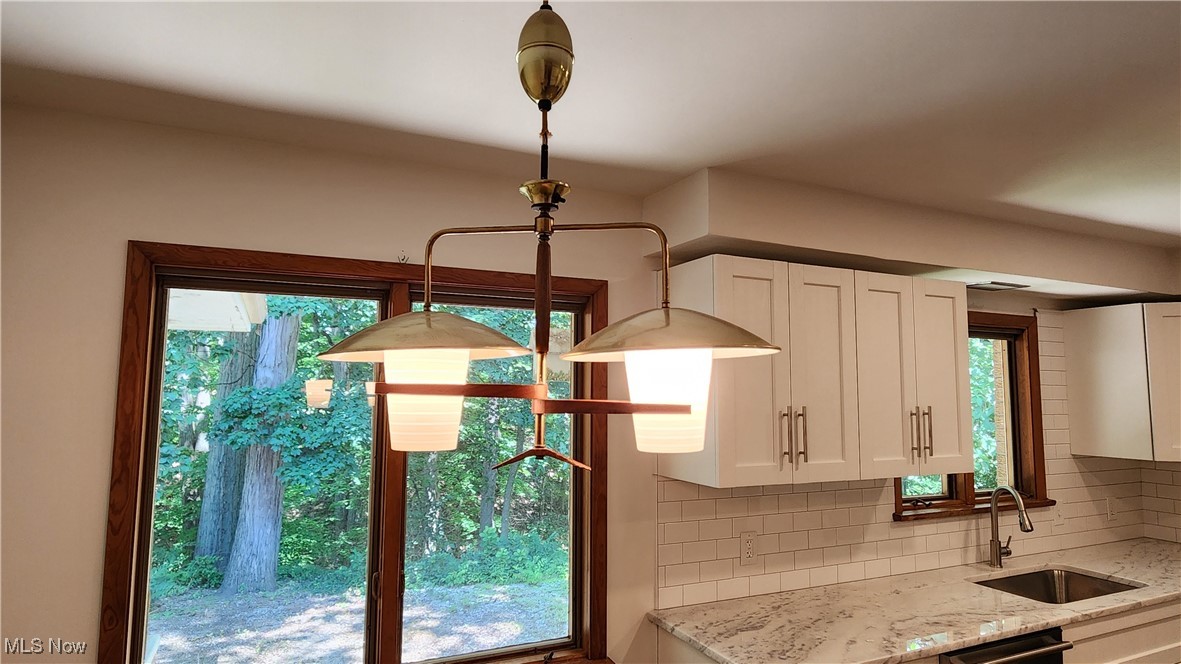 8355 Dalepoint Road Independence, OH 44131 - Photo 5 of 27 Interior details featuring a sink, white cabinetry, light stone counters, and tasteful backsplash