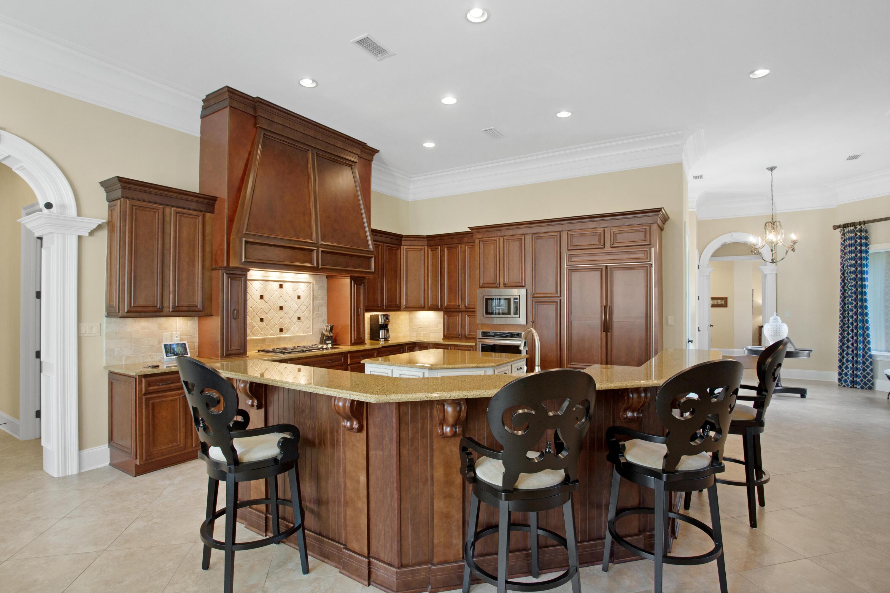 2946 Pine Valley Road Miramar Beach, FL 32550 - Photo 14 of 52 a kitchen with stainless steel appliances kitchen island granite countertop a table chairs and a refrigerator