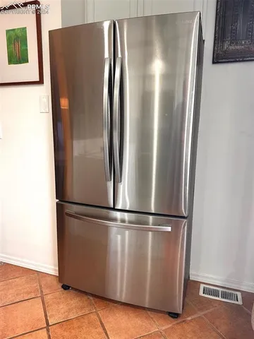 a metallic refrigerator freezer sitting in a kitchen