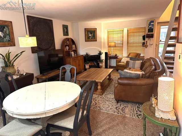 a living room with furniture a large window and a dining table