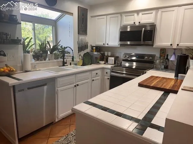 a kitchen with a sink and white appliances