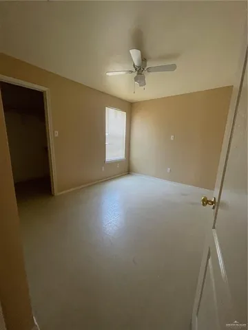 en empty room with windows and fan