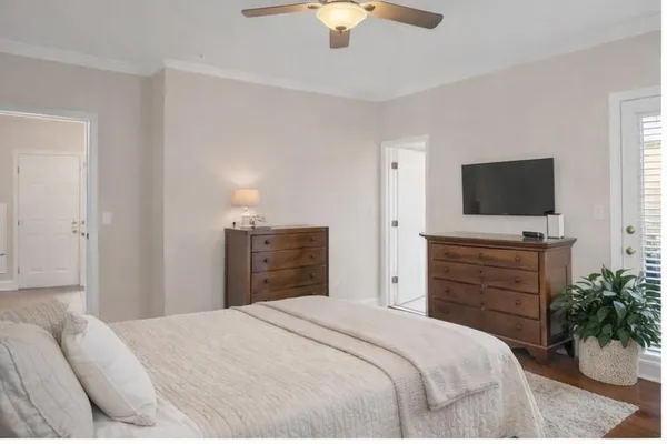 a bedroom with a large bed couch and a large window