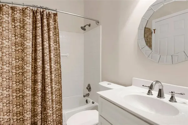 a kitchen that has a sink a microwave oven a stove and white cabinets with wooden floor