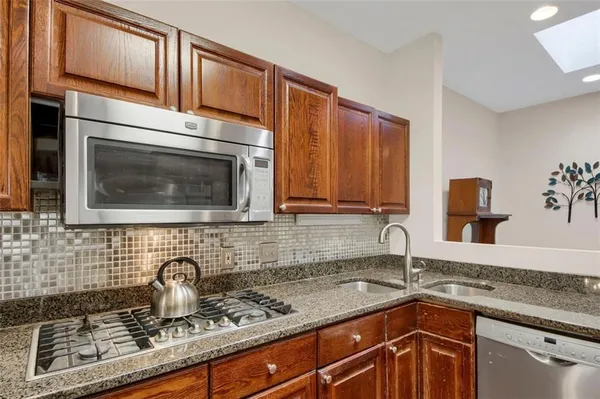 a kitchen with stainless steel appliances granite countertop a sink stove and cabinets