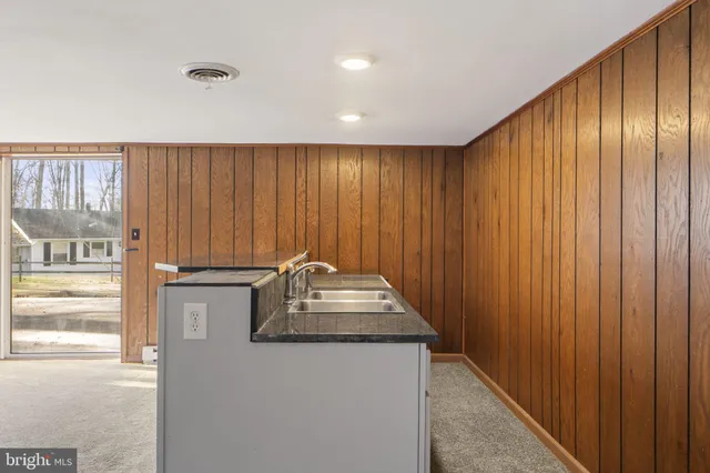 a view of an empty room with wooden floor and window