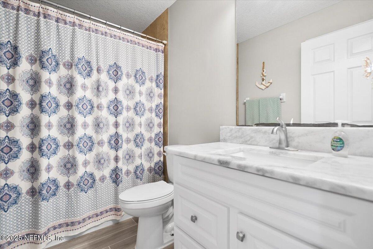 53347 Clear Lake Drive Callahan, FL 32011 - Photo 11 of 41 a bathroom with a granite countertop sink a toilet and a mirror