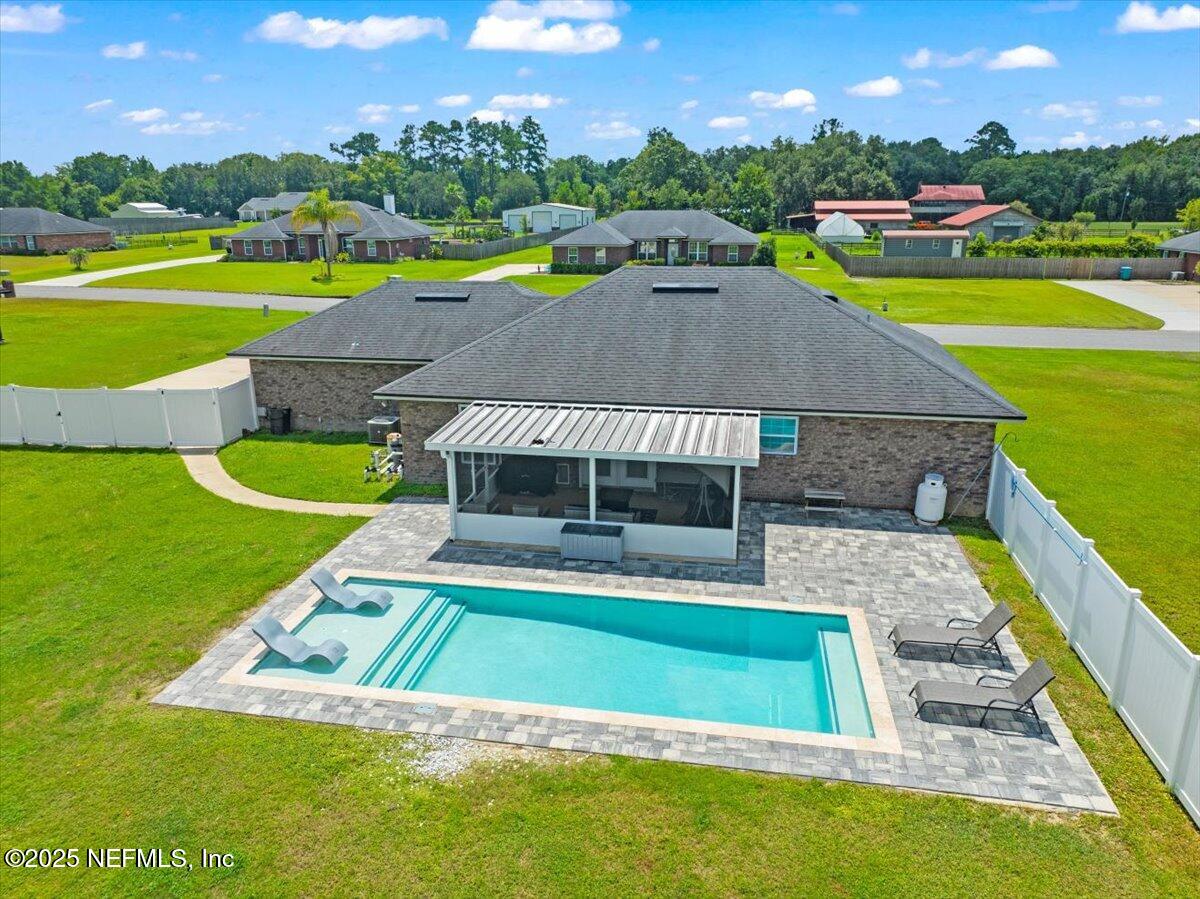 53347 Clear Lake Drive Callahan, FL 32011 - Photo 30 of 41 a view of a swimming pool with lawn chairs and plants