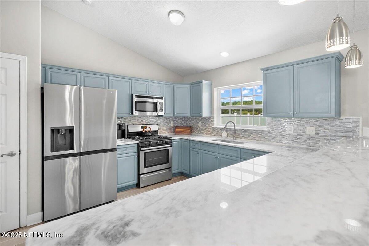 53347 Clear Lake Drive Callahan, FL 32011 - Photo 8 of 41 a kitchen with stainless steel appliances granite countertop a refrigerator sink and stove