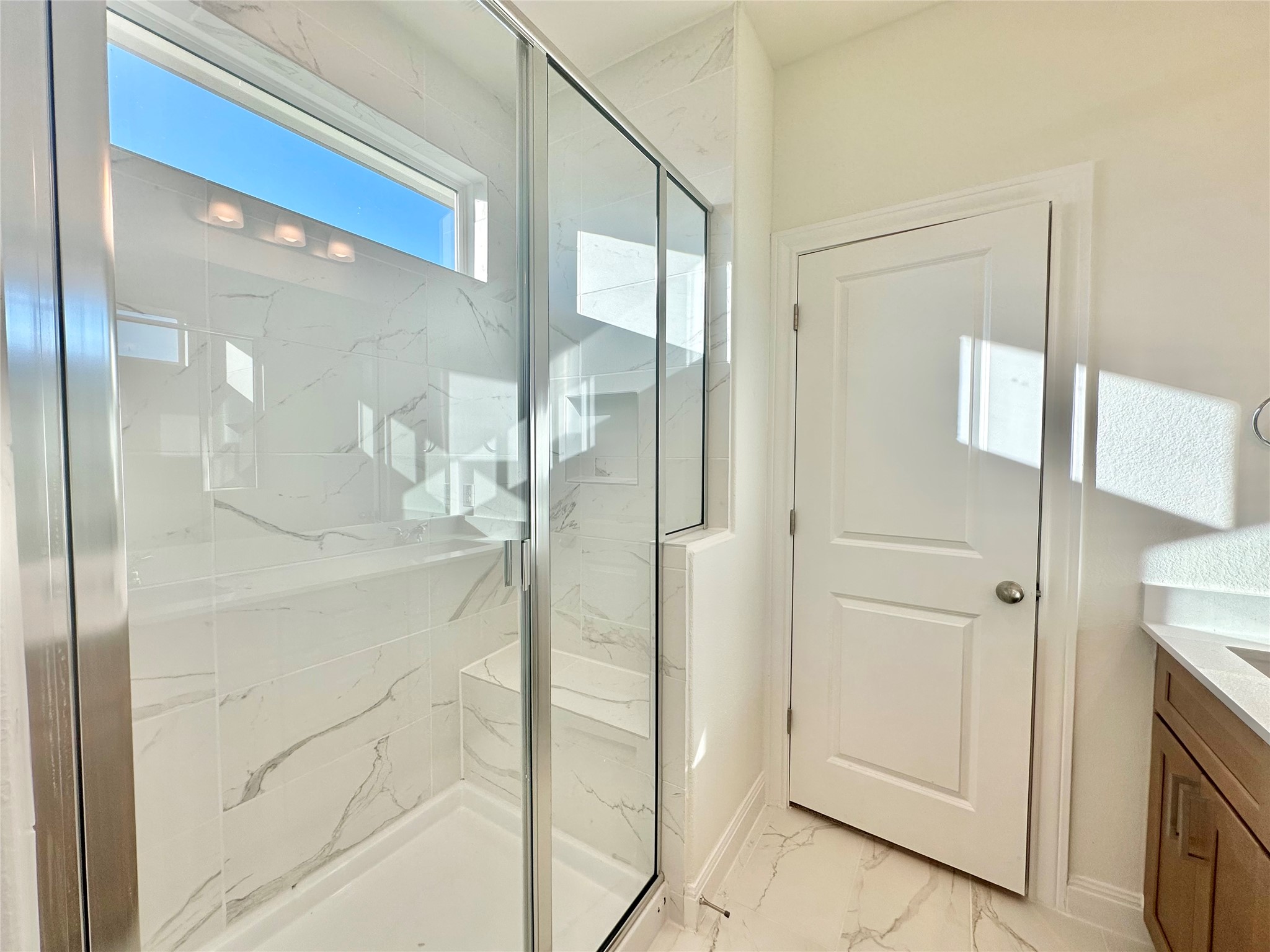 399 Porter Country Parkway Buda, TX 78610 - Photo 20 of 30 a bathroom with a glass shower door and a mirror
