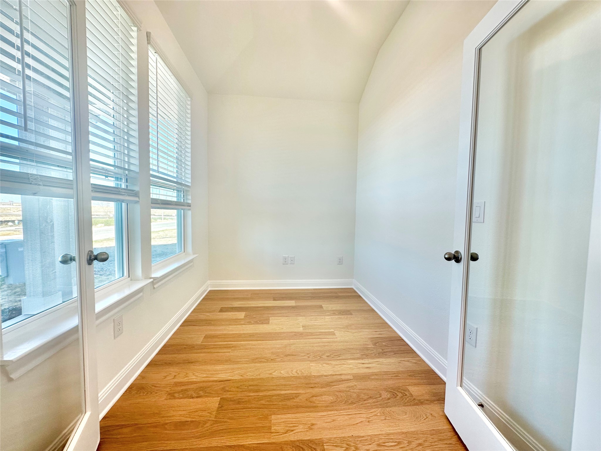399 Porter Country Parkway Buda, TX 78610 - Photo 3 of 30 a view of a hallway with wooden floor and a bathroom