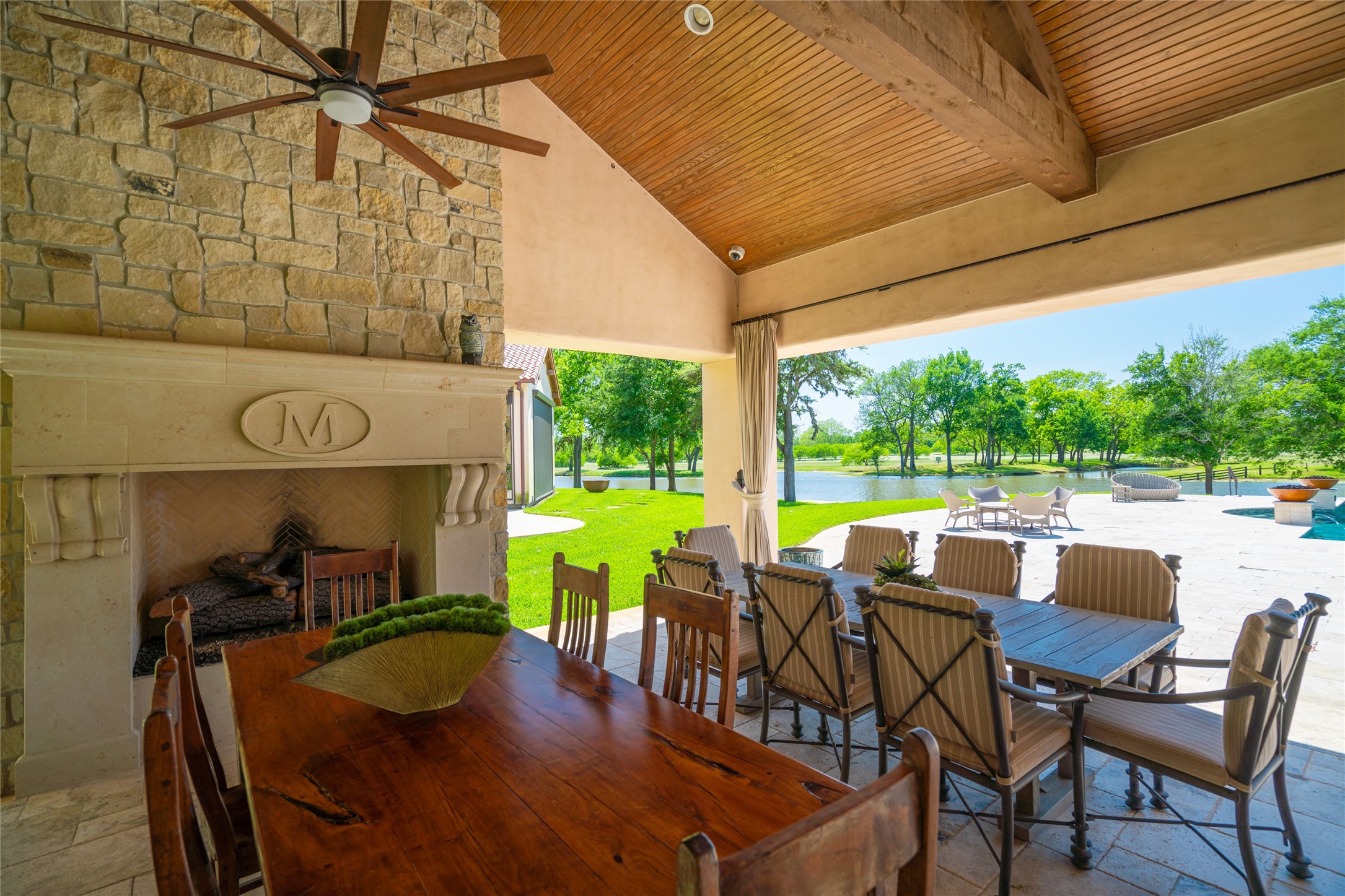 21729 Farm To Market 1887 Hempstead, TX 77445 - Photo 20 of 49 The covered OUTDOOR DINING is located just off the Main House, Pool and Patio areas. Stone tile flooring, pegboard stained wood ceiling with exposed beams/ceiling fans, built-in speakers, stately gas log fireplace (stone surround/mantle) create a relaxed but elegant space to enjoy meals with family and friends. The nearby SUMMER KITCHEN includes stainless Viking gas grill, Elkay stainless sink, griddle space, granite counter.