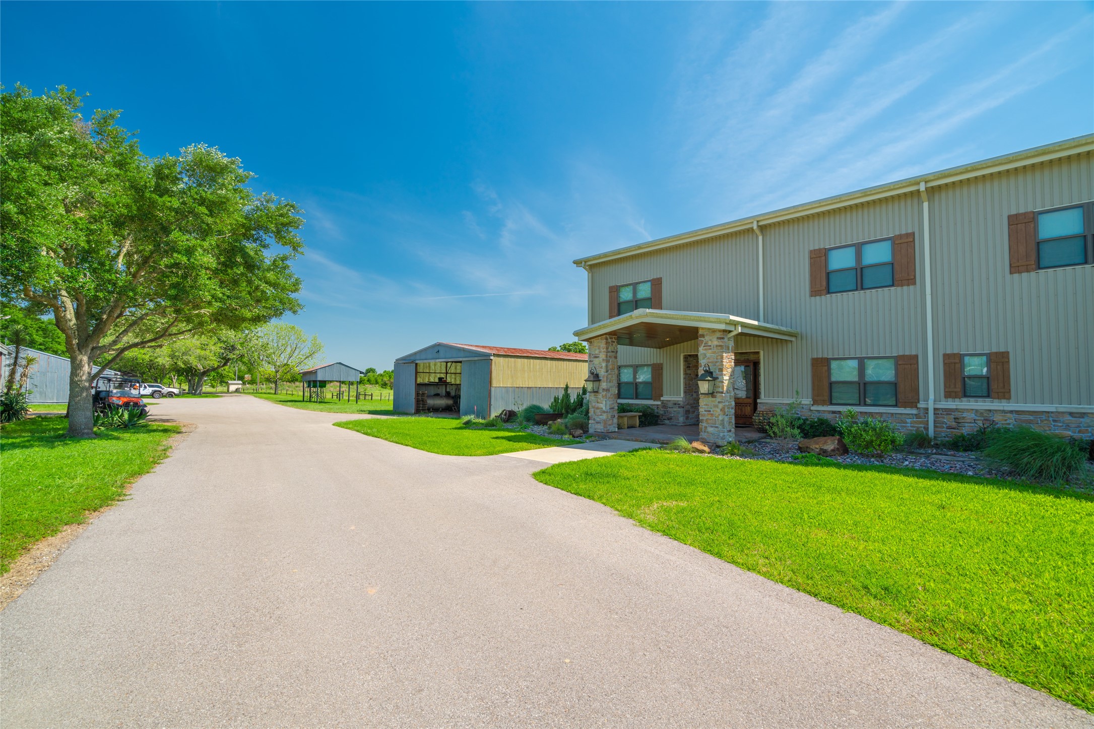 21729 Farm To Market 1887 Hempstead, TX 77445 - Photo 30 of 49 Just off the Broad Oaks Ranch's main entry gate is the Barndominium with its great open event center and housing facility. Its MAIN ENTRY follows In the same design tradition as the Main House with its impressive covered entry/stone pillars/stone walkway/wood planked ceiling - all bordered by a notewothy rock garden.