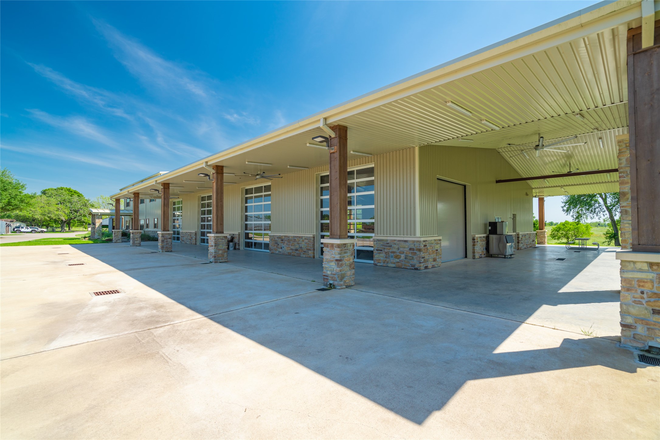 21729 Farm To Market 1887 Hempstead, TX 77445 - Photo 31 of 49 A closer view of the BARNDOMINIUM with its series of four car bays on one side of the building and two car bays on the other side. The main entry is seen at the far end of the building.