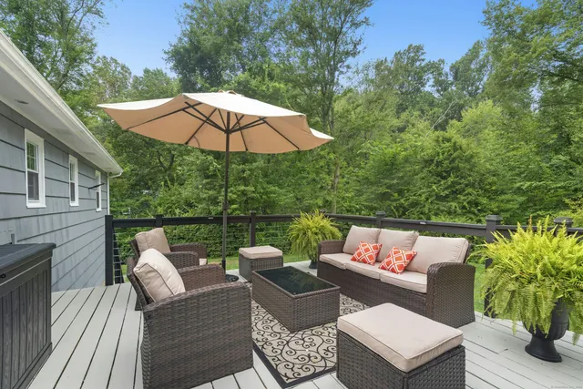a view of patio with couches table and chairs under an umbrella