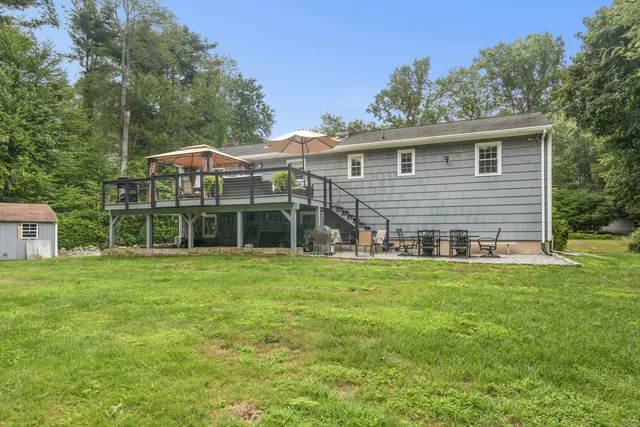 a view of a house with a yard and sitting area