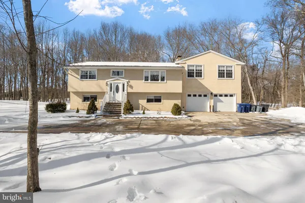 a view of a white house with a yard covered in snow