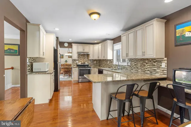a kitchen with stainless steel appliances granite countertop a stove a sink and a microwave