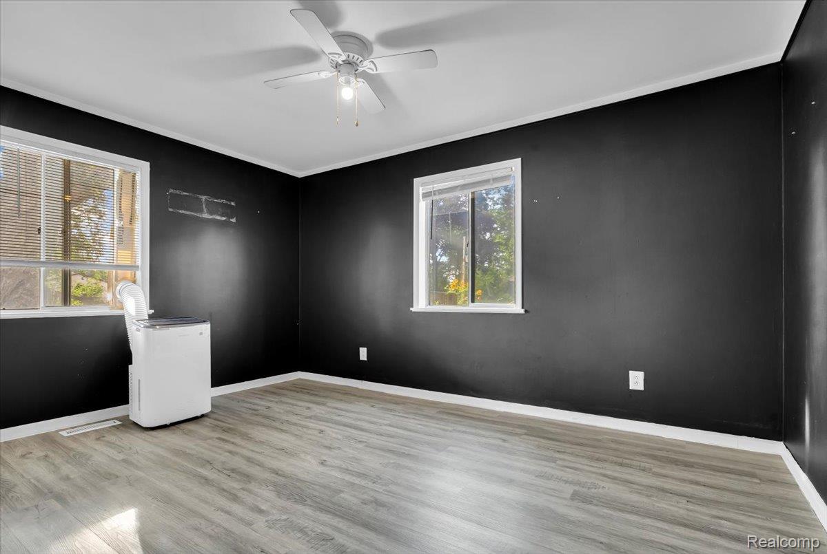 1215 Center Street Inkster, MI 48141 - Photo 13 of 30 Wood-finish flooring with white trim, two windows, and a ceiling fan