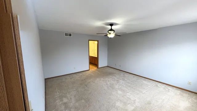 a view of an empty room with a chandelier fan