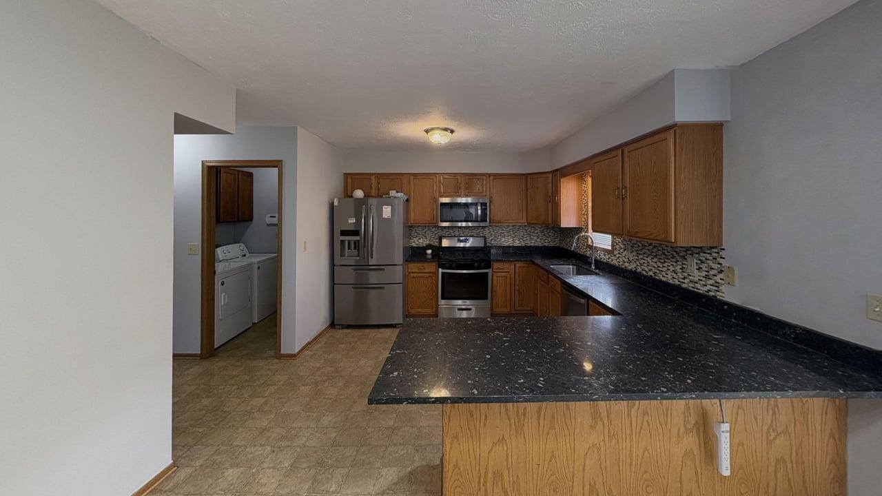 10662 Chicory Ridge Way Roscoe, IL 61073 - Photo 5 of 37 a kitchen with stainless steel appliances granite countertop a sink a stove and a refrigerator
