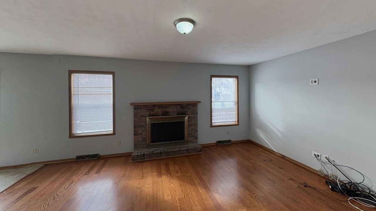 10662 Chicory Ridge Way Roscoe, IL 61073 - Photo 7 of 37 an empty room with wooden floor fireplace and windows