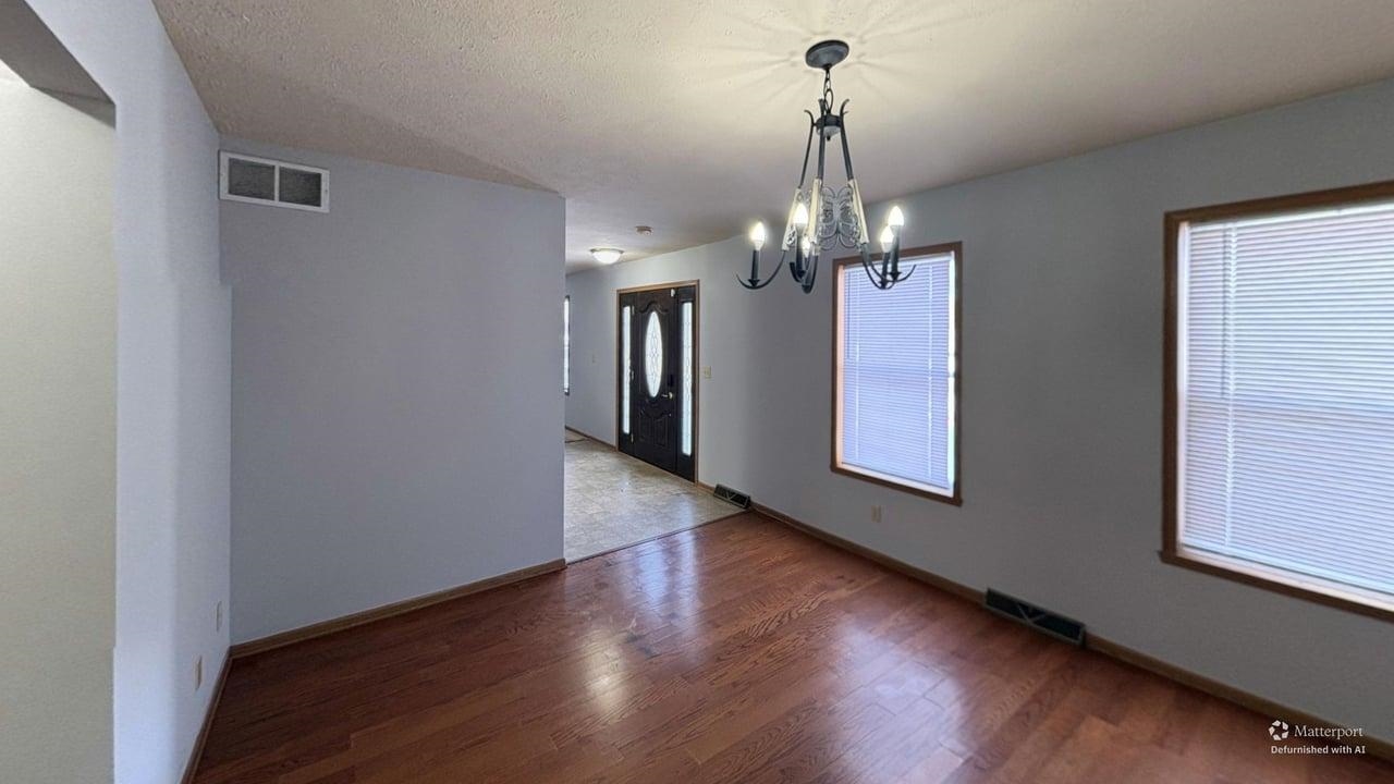 10662 Chicory Ridge Way Roscoe, IL 61073 - Photo 8 of 37 a view of a hallway with wooden floor and chandelier