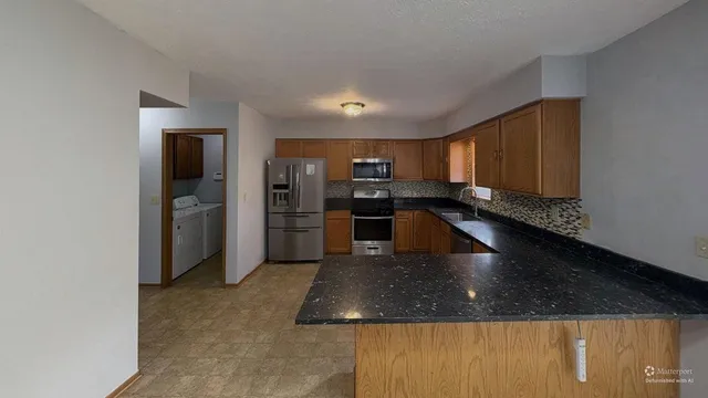 a kitchen with stainless steel appliances granite countertop a sink refrigerator and microwave