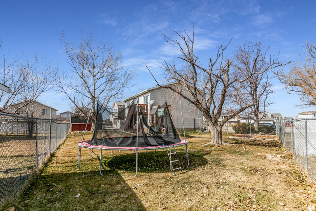 4239 West 5325th Street South Roy, UT 84067 - Photo 26 of 26 Fenced backyard featuring a trampoline and a residential view