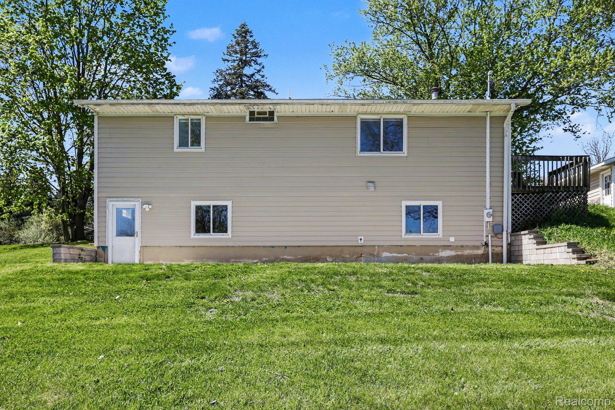 1405 Swarthout Road Pinckney, MI 48169 - Photo 26 of 31 Rear view of house featuring a yard and a deck