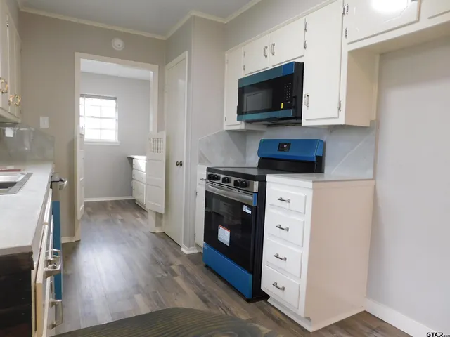 a view of a kitchen with a sink cabinets and wooden floor