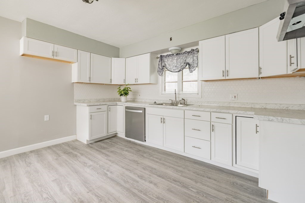 17 Spring Street Ware, MA 01082 - Photo 8 of 28 a kitchen with white cabinets appliances a sink and a window