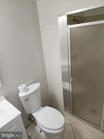 a white toilet sitting next to a shower