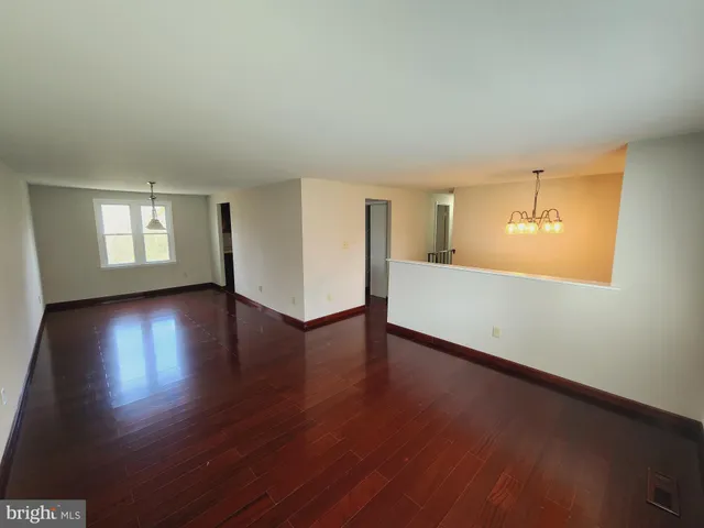 a view of a livingroom with wooden floor and a kitchen