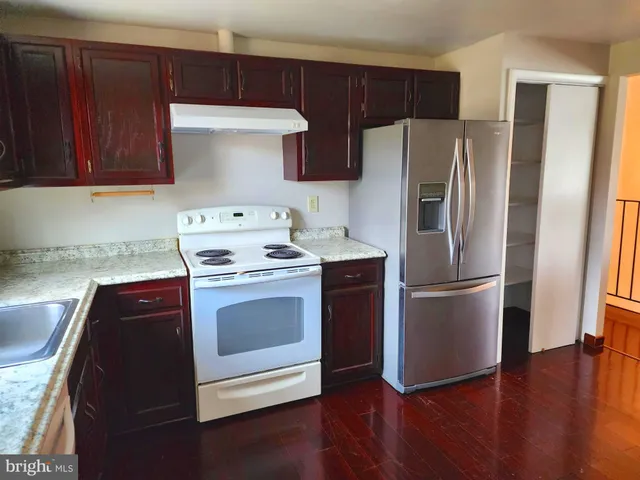 a kitchen with a refrigerator sink and cabinets