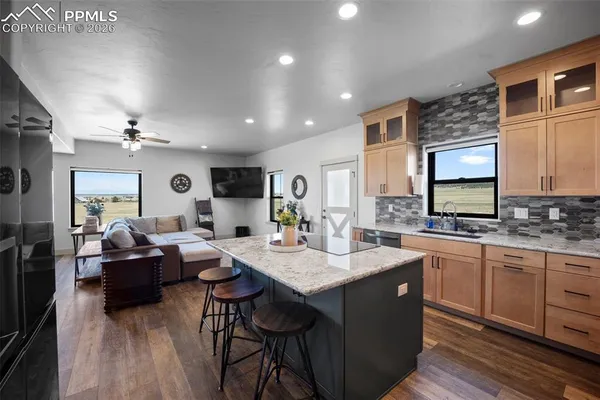 a living room with kitchen island granite countertop furniture and a kitchen view