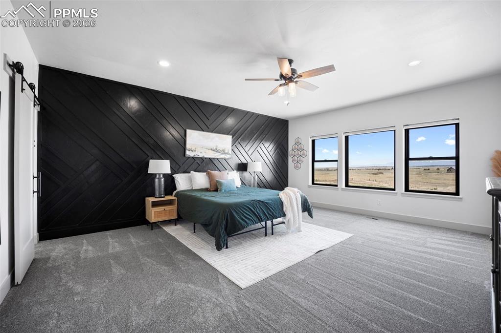 16535 Sweet Road Peyton, CO 80831 - Photo 17 of 45 a spacious bedroom with a large bed and windows