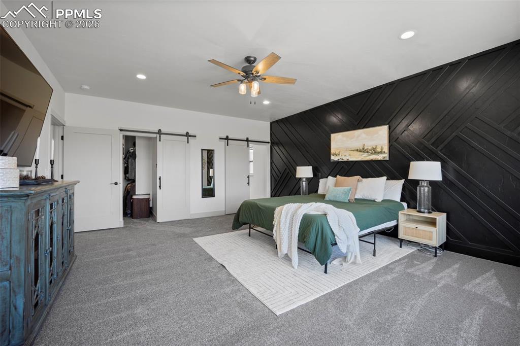 16535 Sweet Road Peyton, CO 80831 - Photo 18 of 45 a bedroom with a bed and a chandelier