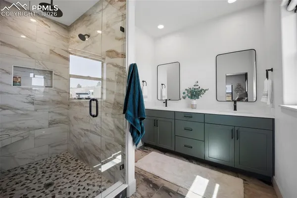 a bathroom with a double vanity sink a mirror and shower