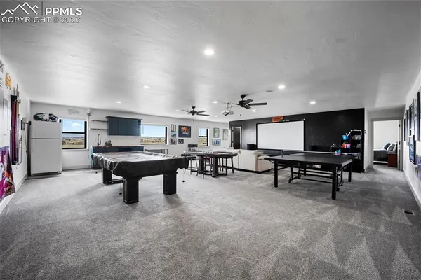 a living room with furniture a pool table and a fireplace
