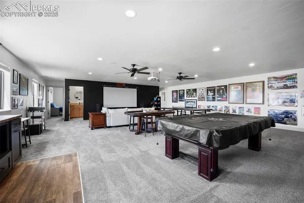 a large living room with stainless steel appliances kitchen island granite countertop a refrigerator and a stove top oven