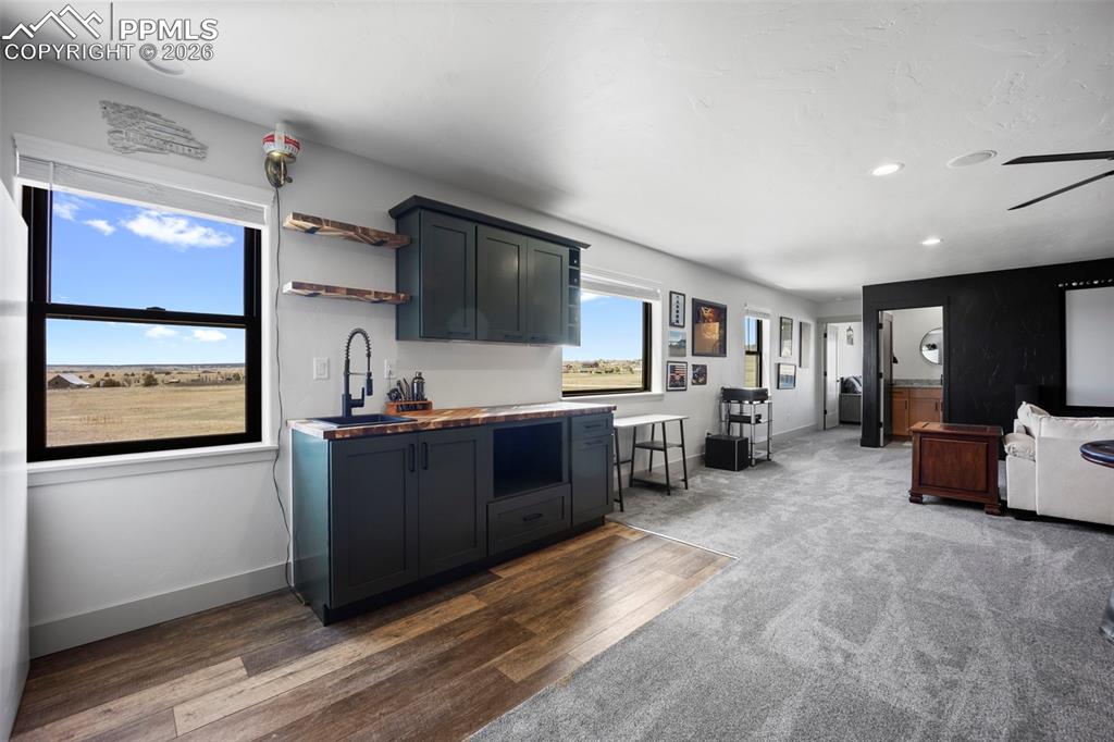 16535 Sweet Road Peyton, CO 80831 - Photo 31 of 45 a large living room with stainless steel appliances kitchen island granite countertop a refrigerator and a stove top oven